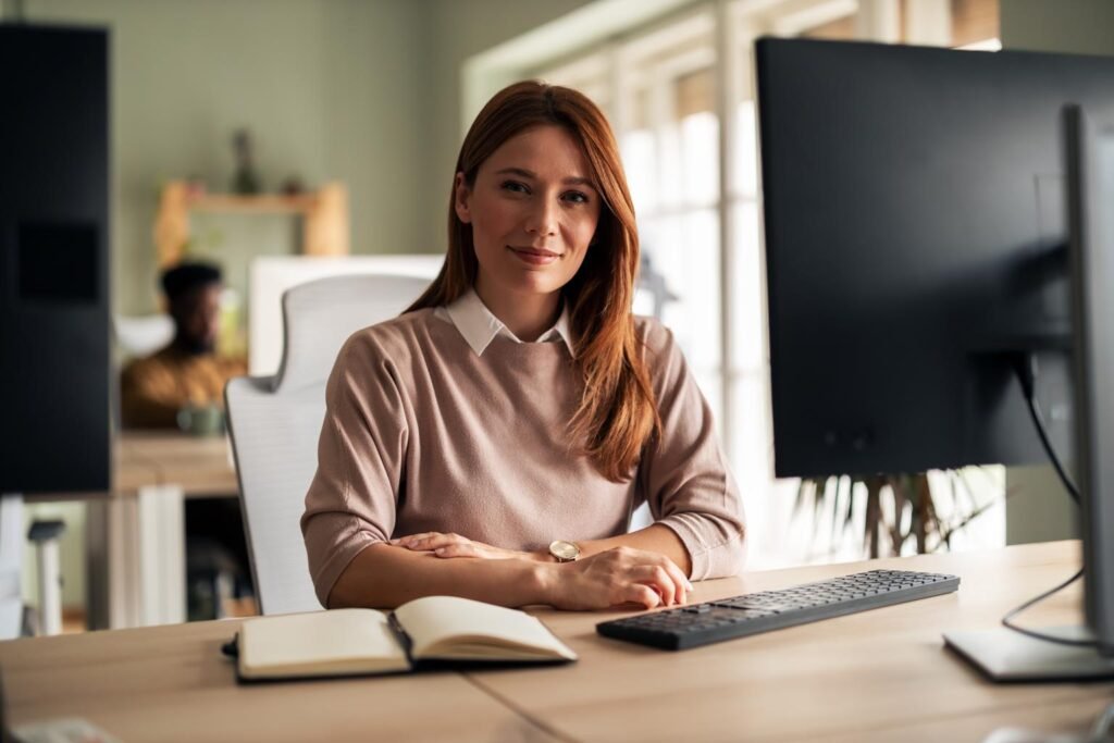 Proper ergonomic sitting posture at a desk with monitor at eye level and feet flat on the floor