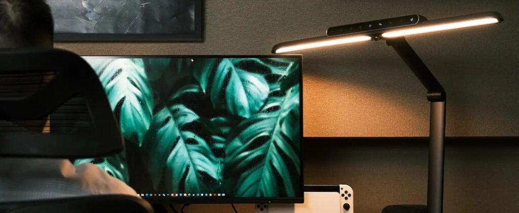 desk lamp positioned to side of monitor reducing glare and eye strain